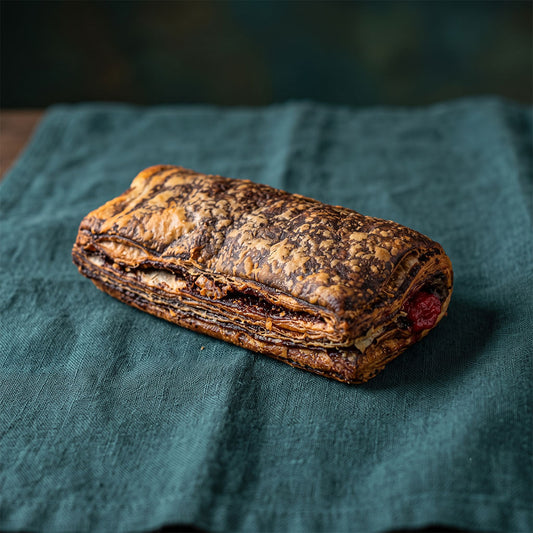 Csokoládés-málnás töltelékű, ropogós leveles tészta sötétzöld textil alapon.