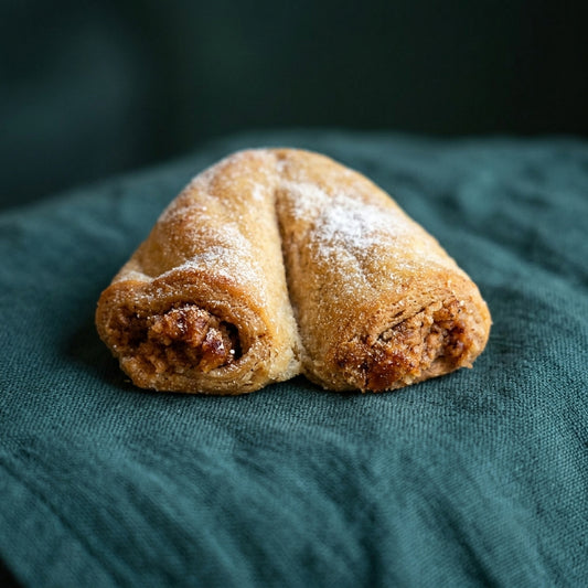 Porcukorral meghintett, patkó alakú kelt tészta, gazdag diós töltelékkel.